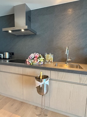 A modern kitchen with a built-in sink, stainless steel appliances, and a decorative flower arrangement.
