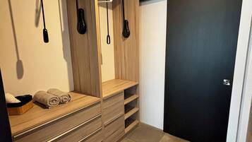 Un baño moderno con tocador de madera, perchero y puerta negra.