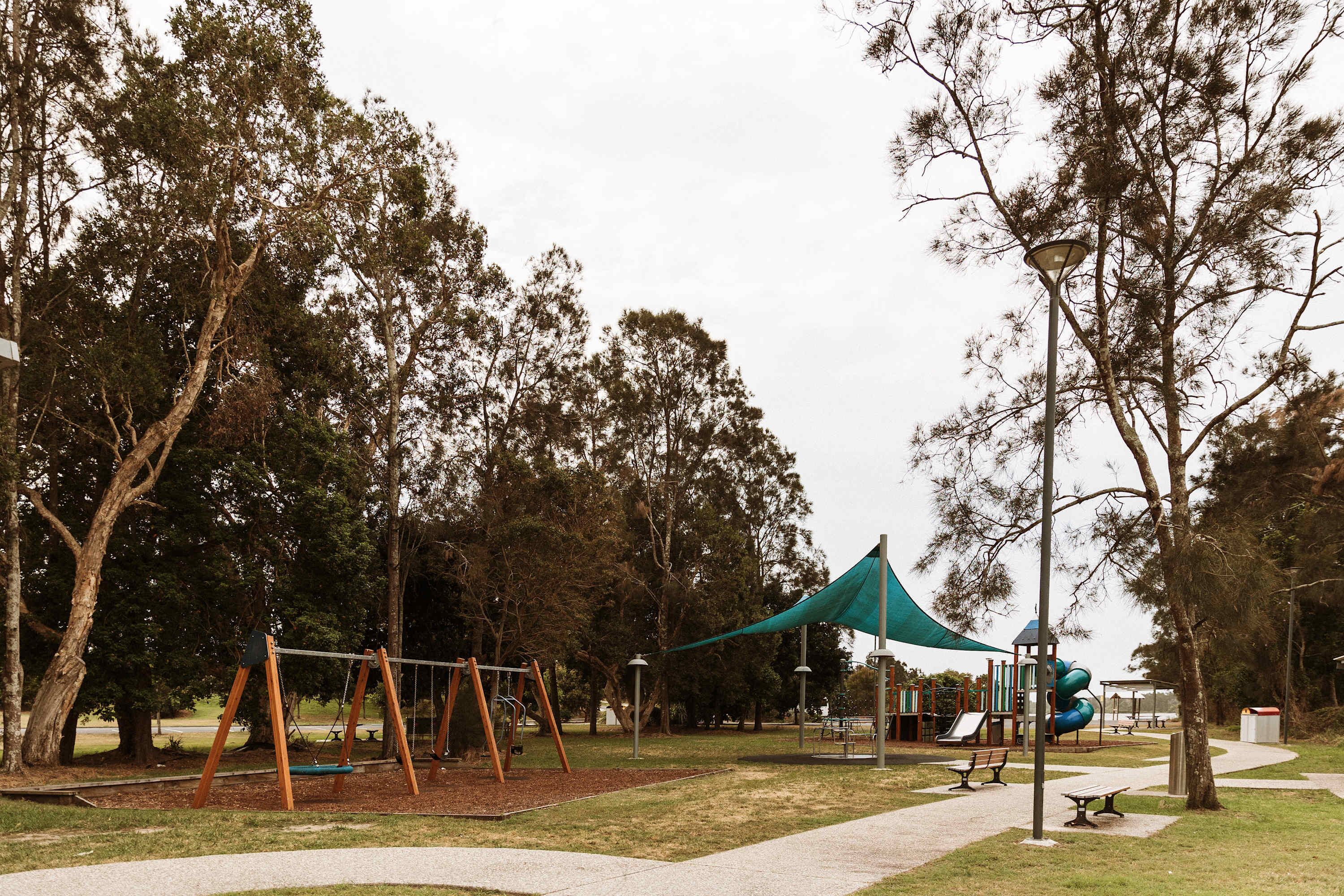 A park with a swing set, a slide, and a picnic area.