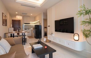 A modern living room with a sofa, coffee table, and a flat-screen TV mounted on the wall. - The Collection Madison Tower (Ho Chi Minh City)