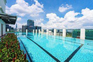 A rooftop infinity pool with a city skyline view, surrounded by modern buildings and a clear sky. - The Collection Madison Tower (Ho Chi Minh City)