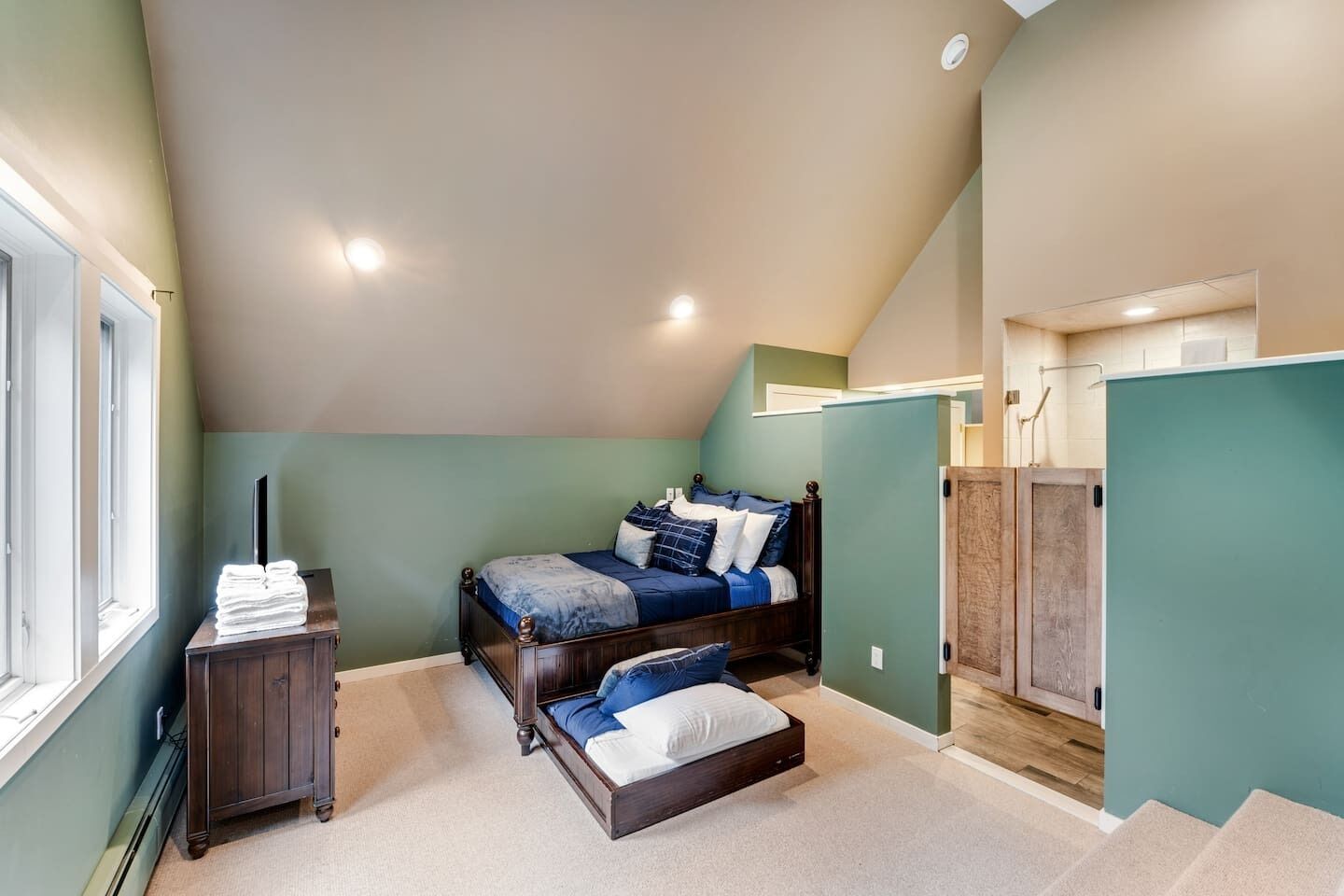 A bedroom with a bed, a nightstand, a dresser, and a closet.