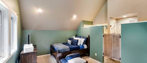 A bedroom with a bed, a nightstand, a dresser, and a closet.