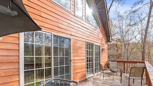 A wooden deck with a trampoline and outdoor seating. - Wooded Cabin Escape w Fire Pit & Family Ready (Berkeley Springs)