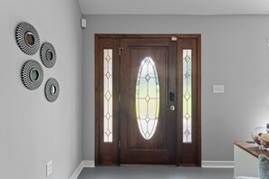 A wooden door with a glass panel and decorative metal pieces on the wall. - Spacious Foley Retreat with Fenced Yard, Pet Friendly (Foley)