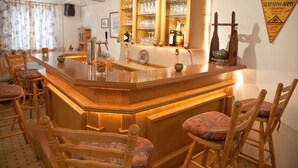 A bar area with wooden chairs and a bar counter. - Apartment Balsberg southwest with 2 bedrooms and large balcony with mountain view (Unterwössen)