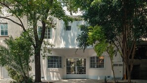 Un edificio con fachada blanca, ventanas amplias y un letrero que dice "CHOLULA CONDEZA HOTEL".