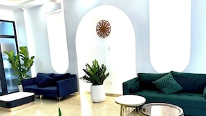 A modern lobby with two sofas, a coffee table, and a round table. - Mây House Grandworld on the beach (Phu Quoc)