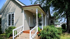 A two-story house with a porch, a front door, and a mailbox. - 3-BR + Firepit, Coffee Bar & Grill (Bourbon)