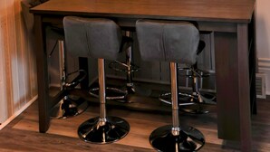 A dining area with a wooden panel wall, a chandelier, and several framed wall decorations. - 3-BR + Firepit, Coffee Bar & Grill (Bourbon)