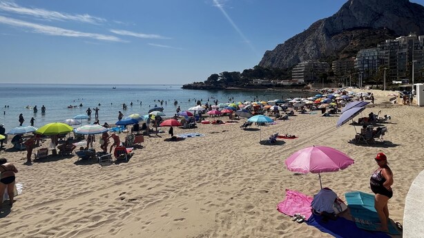 A crowded beach with people sunbathing and swimming, colorful umbrellas, and a prominent mountain in the background. - Ground-floor apartment in Frentemar complex for 4 people. (Calp)