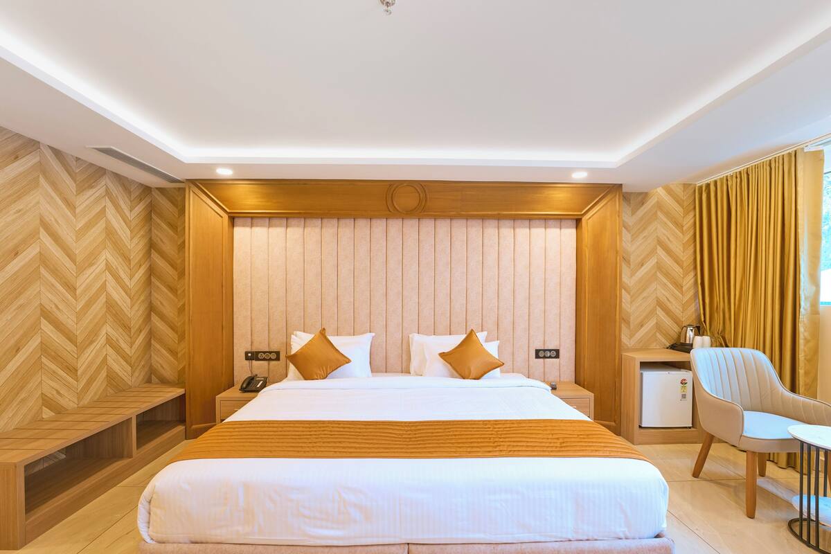 Une chambre d’hôtel avec un grand lit, des tables de chevet, un bureau et une chaise.