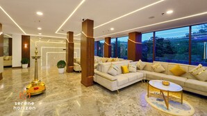 A modern living room with a sectional sofa, a coffee table, and a decorative floor lamp. - Serene Horizon Resort (Kumily)