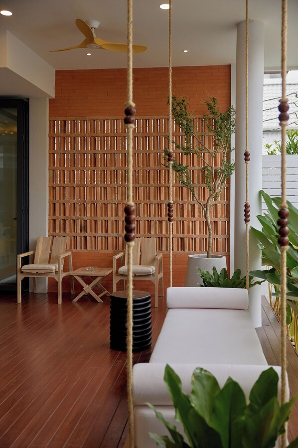 A modern interior with a wooden floor, a white sofa, and a wooden partition wall.