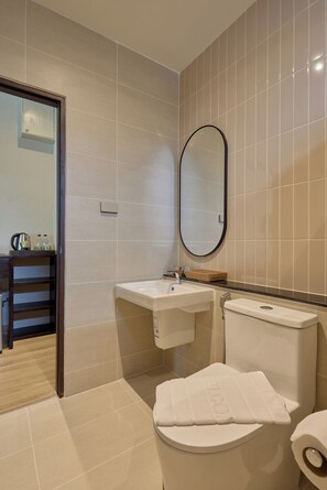 Un baño con inodoro, lavabo y espejo.