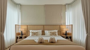 Una habitación de hotel con una cama grande, dos mesitas de noche con lámparas y un cabecero.