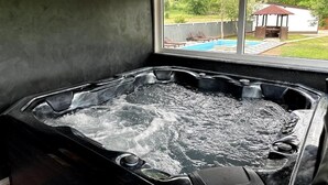 A hot tub with a view of a backyard with a pool and a gazebo. - Rijeka Villa-Spacious 4BR with Pool (East Sarajevo)