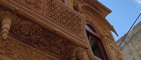 A building with intricate architectural carvings and a large window.