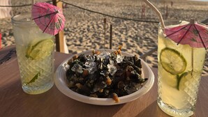 Two drinks with lime slices and umbrellas on a table with a beach view in the background. - Azulmaris - Directly on the beach | Terrace & sea view (Vila do Conde)
