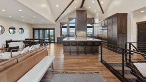 Une cuisine spacieuse dotée d’un îlot central, de planchers en bois et d’un design moderne.