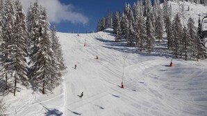 A snowy ski slope with trees and ski lifts. - House in Bad Kleinkirchheim by Ski Slope (Bad Kleinkirchheim)