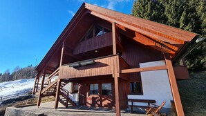 A wooden chalet with a balcony, stone steps, and a view of a snowy landscape. - House in Bad Kleinkirchheim by Ski Slope (Bad Kleinkirchheim)
