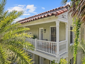 Une maison à deux étages dotée d’un balcon, d’un toit en tuiles et d’une façade en stuc.