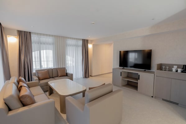 A modern living room with a sofa set, a coffee table, a flat-screen TV, and a cabinet. - Yevlakh City Hotel (Yevlakh)