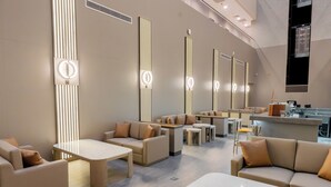 A modern hotel lobby with sofas, tables, and a bar area. - Yevlakh City Hotel (Yevlakh)