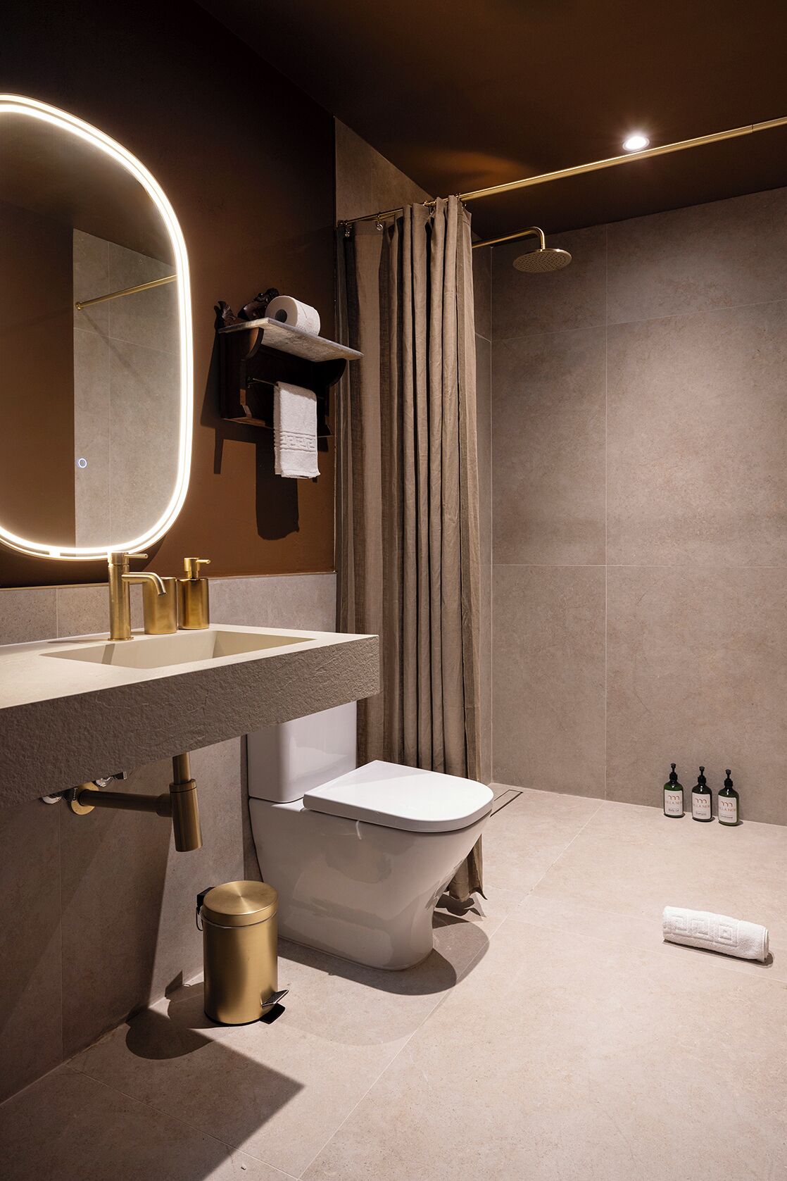 Un baño moderno con tocador, inodoro, ducha y toallero.