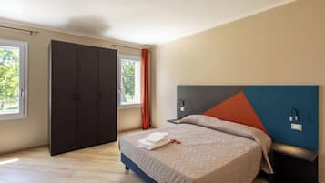 A modern bedroom with a bed, wardrobe, and bedside table.