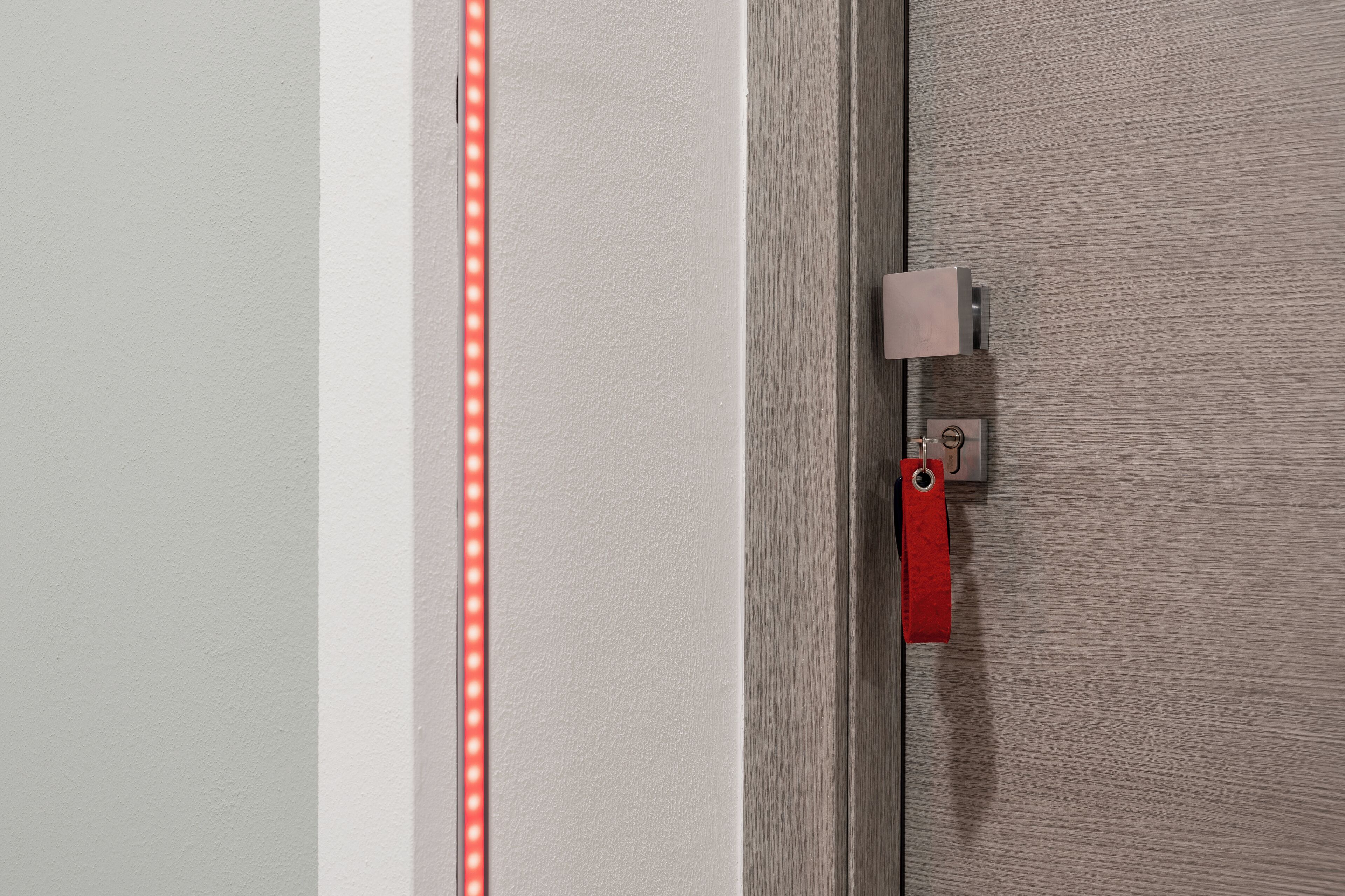 Uma porta com maçaneta vermelha, olho de fechadura e tranca.