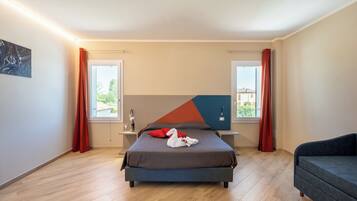 A modern bedroom with a bed, a sofa, and a large window.