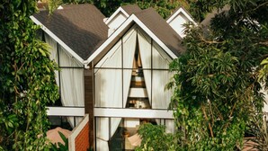 A modern house with a swimming pool surrounded by lush greenery. - Moon Rock Villas (Batubulan)