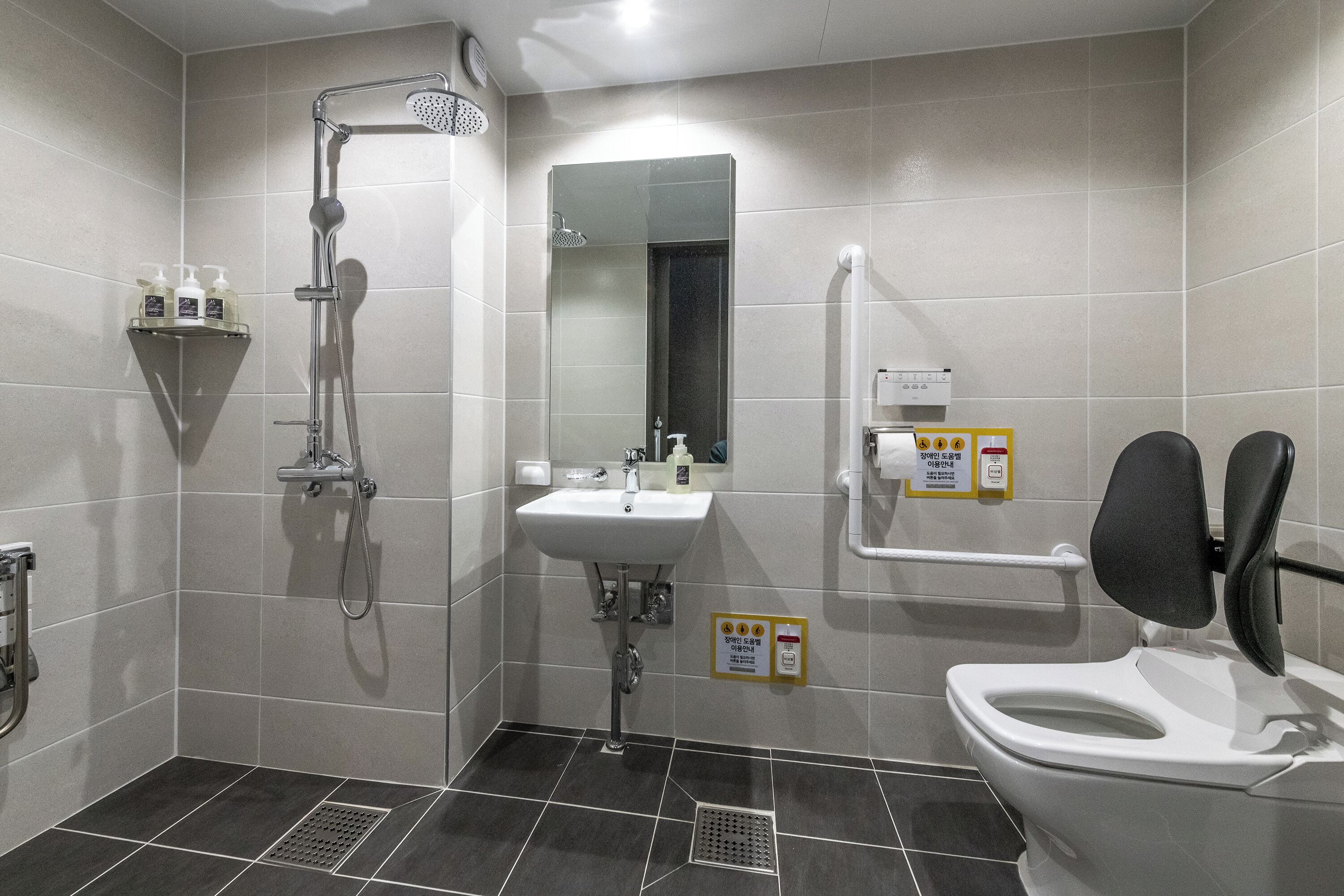 A modern bathroom with a shower, sink, and toilet.