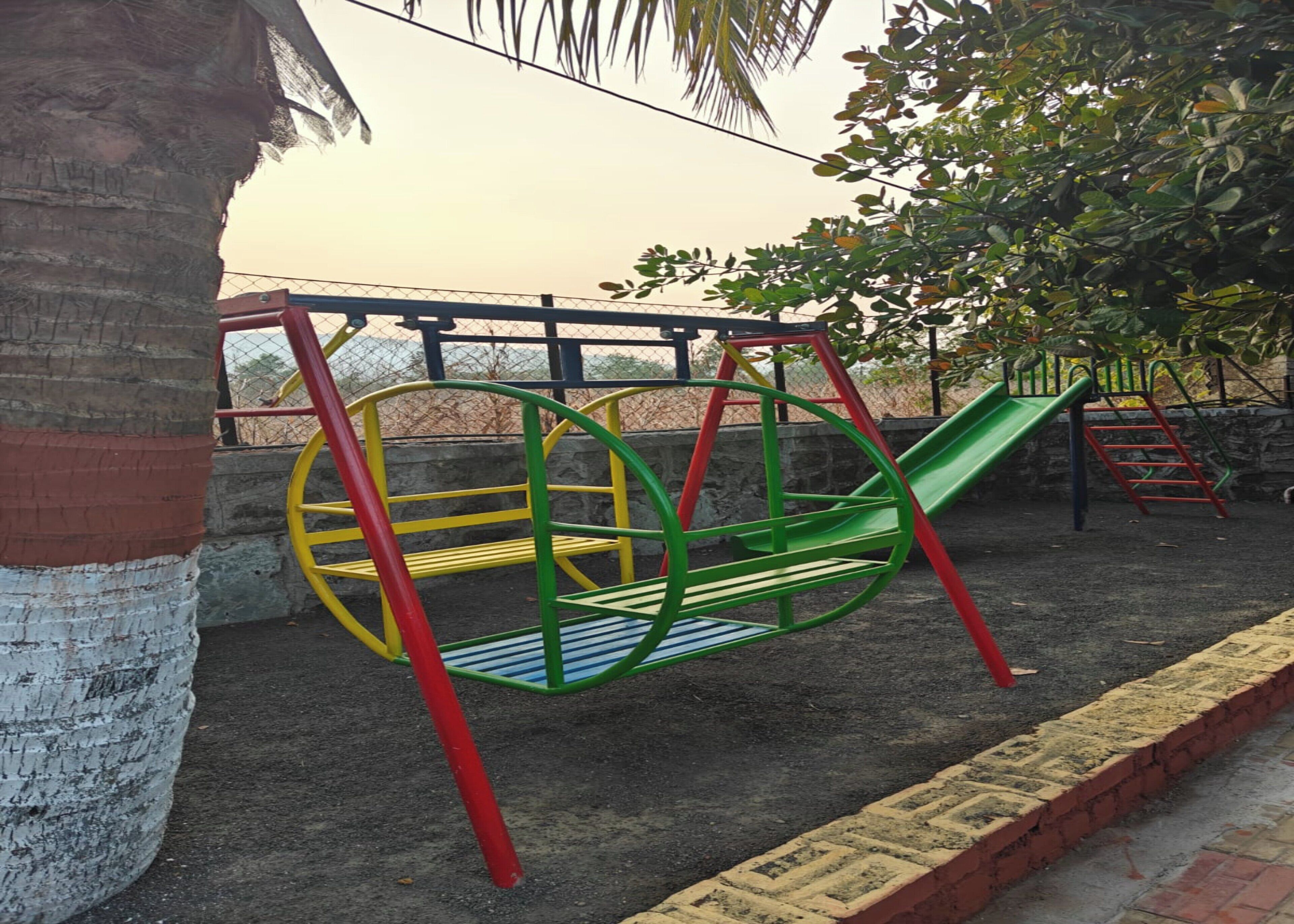 A playground with a swing set, slide, and climbing structure.