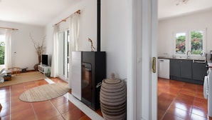 Una cocina moderna con horno empotrado, un comedor con mesa y sillas, y un jarrón grande.