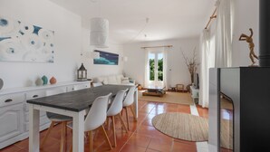 Una cocina moderna con una mesa de comedor, sillas y un amplio ventanal.