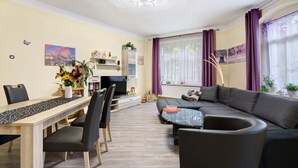 Una sala de estar moderna con una mesa de comedor, sofá y televisor.