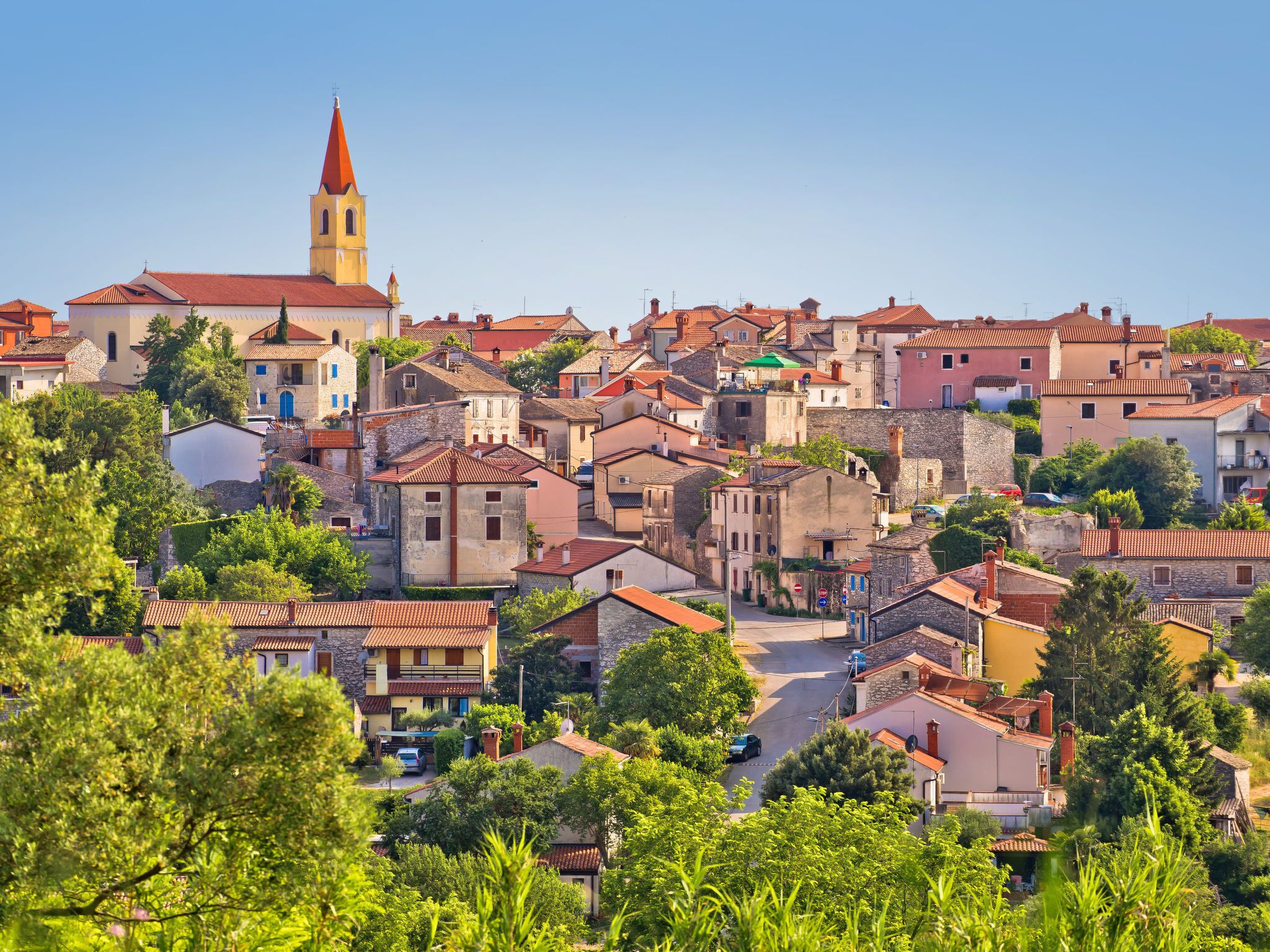 A historic town with a prominent church tower, narrow streets, and traditional architecture.