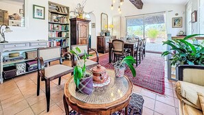 Un salon chaleureux avec une cheminée, des étagères à livres et des fauteuils confortables.