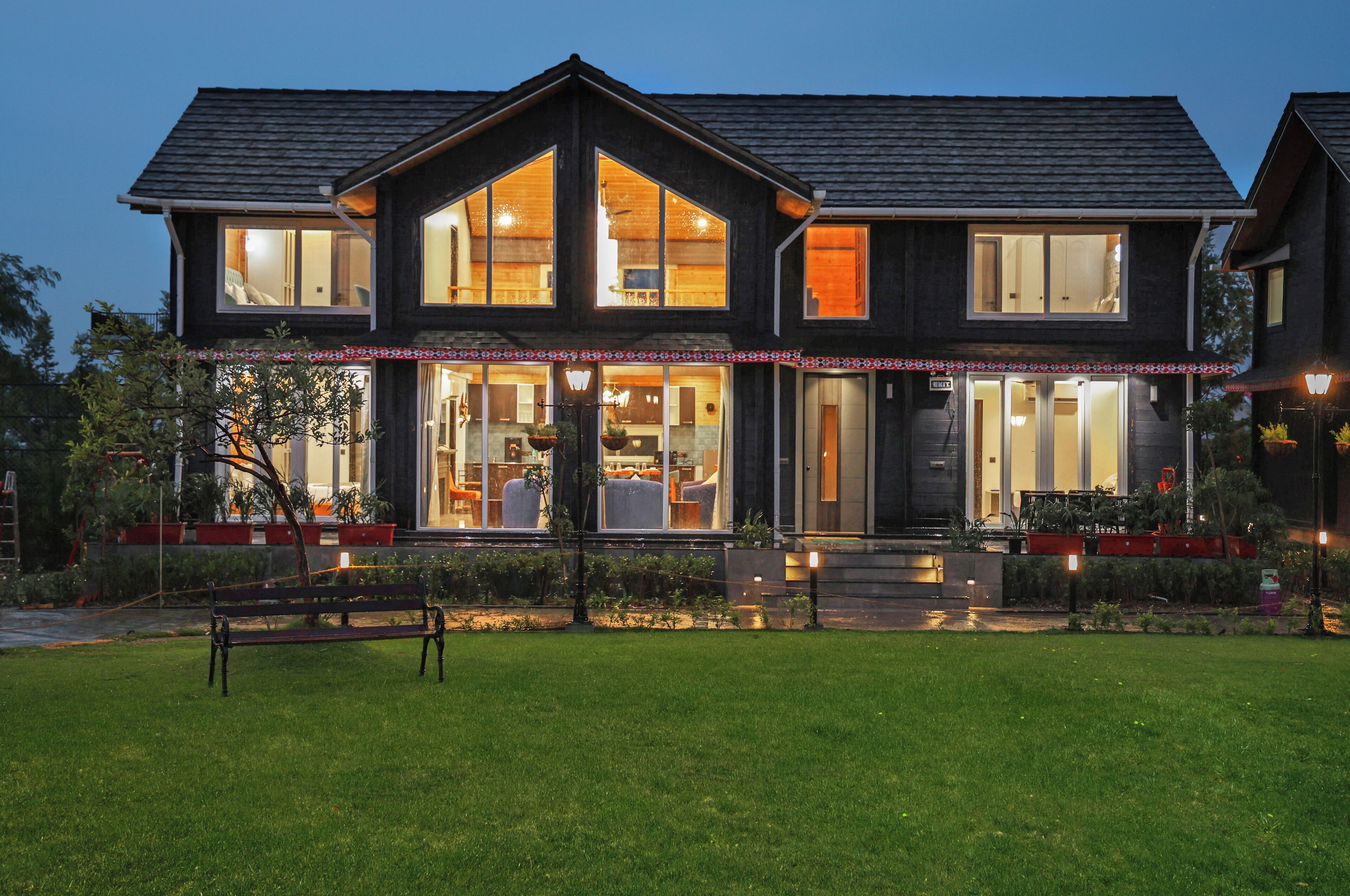 A two-story house with large windows, a front porch, and a well-maintained lawn.