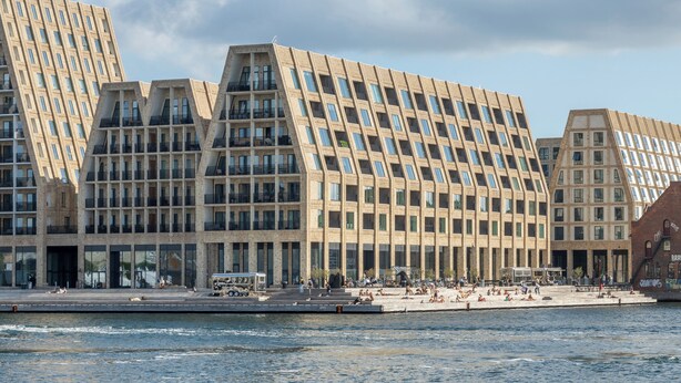 Un edificio moderno con un diseño angular distintivo, que cuenta con varios balcones y grandes ventanales.