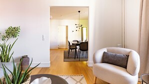 Una sala de estar moderna con un sofá, una mesa de centro y un comedor al fondo.