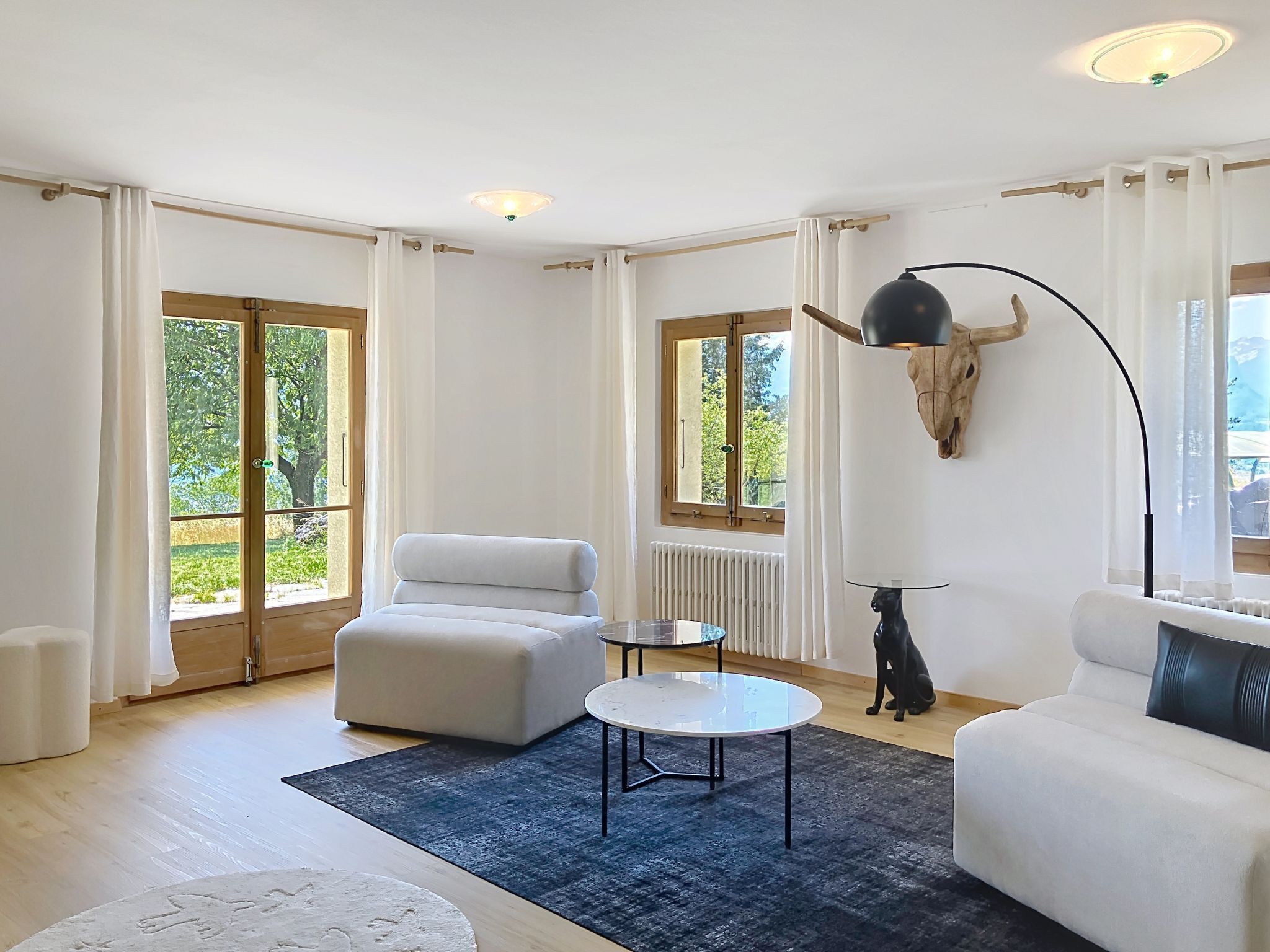 Ein modernes Wohnzimmer mit einer Couch, einem runden Couchtisch und einer Wanddekoration.