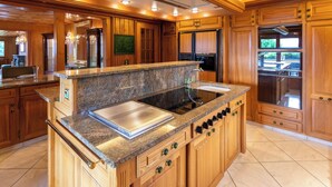A kitchen with wooden cabinets, granite countertops, and stainless steel appliances. - Champ de Brent by Interhome (Ollon)