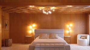 A bedroom with a large bed, two bedside tables, a chair, and a ceiling light fixture. - Champ de Brent by Interhome (Ollon)