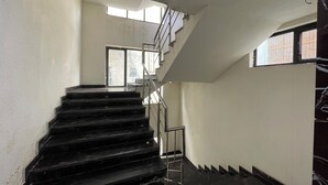 Un escalier avec une rampe métallique menant à un palier.