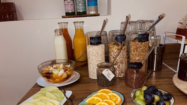 A breakfast buffet with various fruits, cereals, and beverages. - Haus Borkum (Borkum)