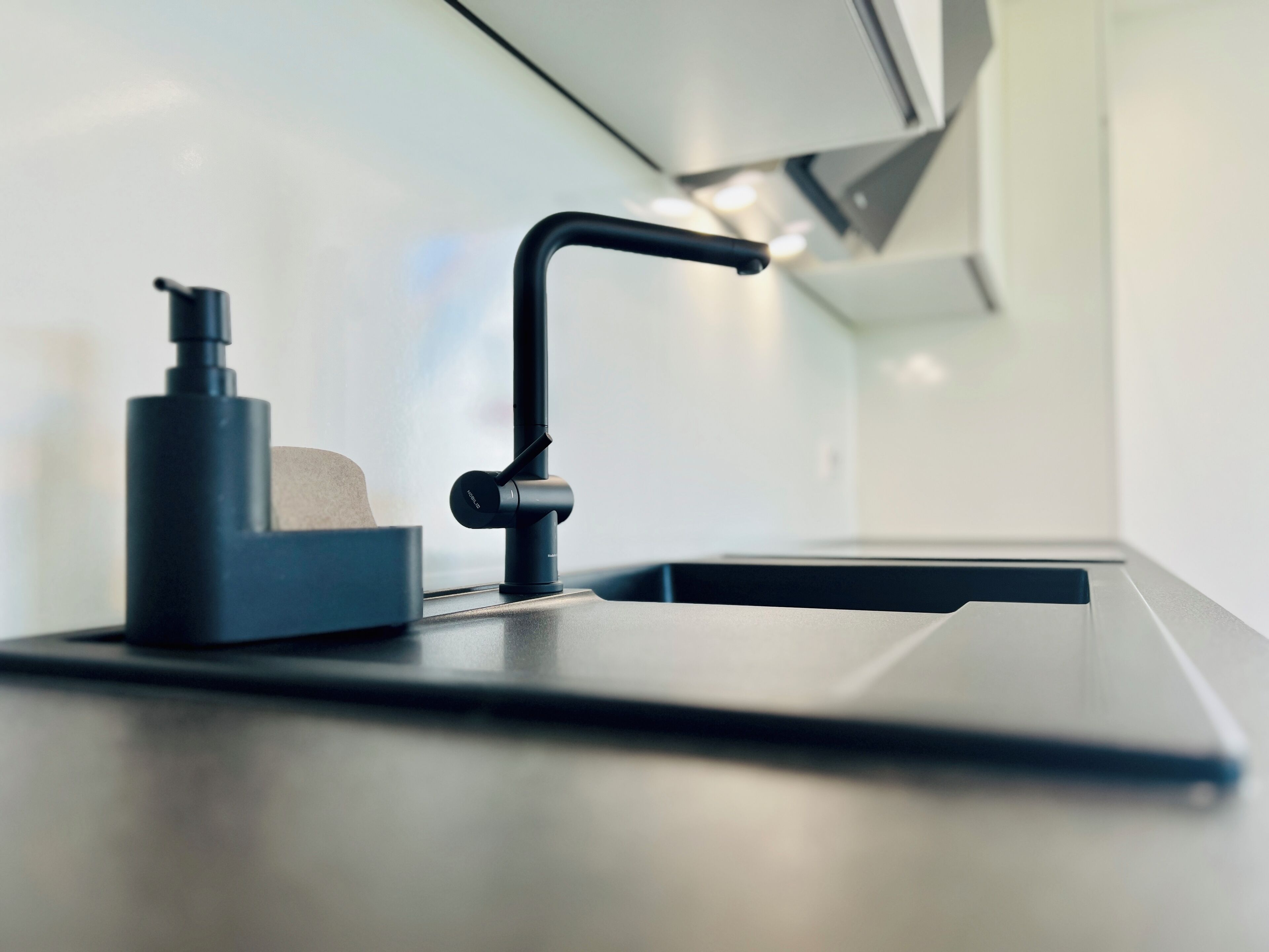 Une cuisine moderne dotée d’une machine à café intégrée et d’un design épuré et minimaliste.